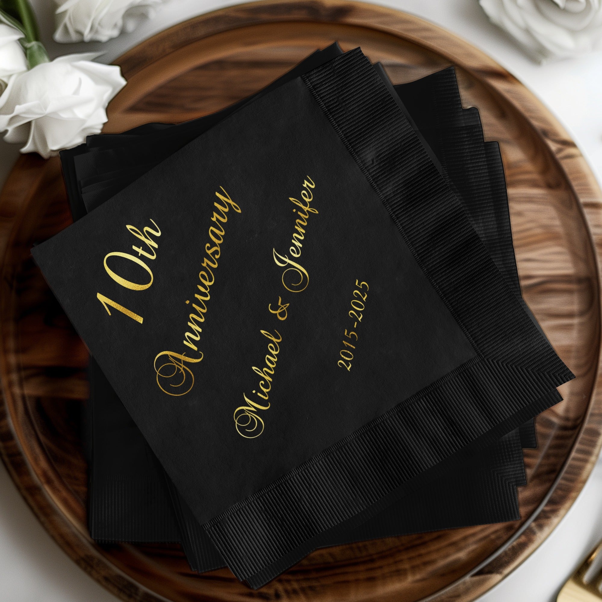 Black napkins with "10th Anniversary Michael & Jennifer 2015-2025" in gold.