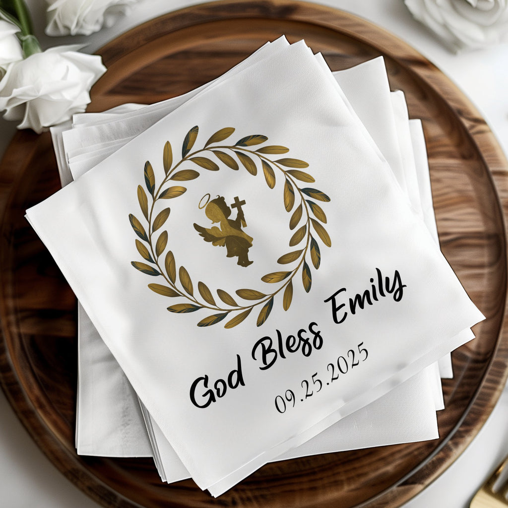 White napkins with "God Bless Emily" and a date below an angel in a wreath.