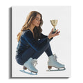 Young woman in figure skates holding a gold trophy.