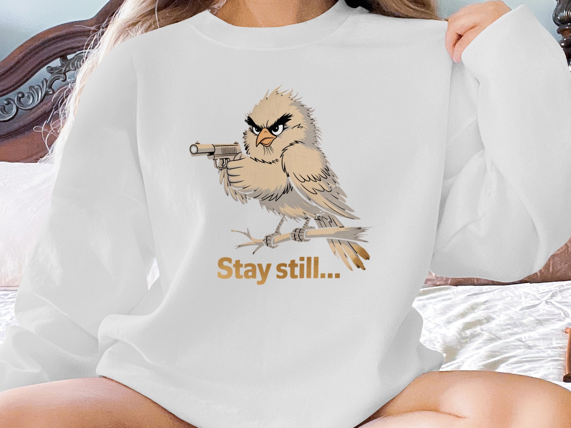 Cartoon bird with a gun on a branch, text "Stay still...".