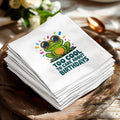 White napkins with a cartoon frog wearing sunglasses and the text "Too cool to care about birthdays."