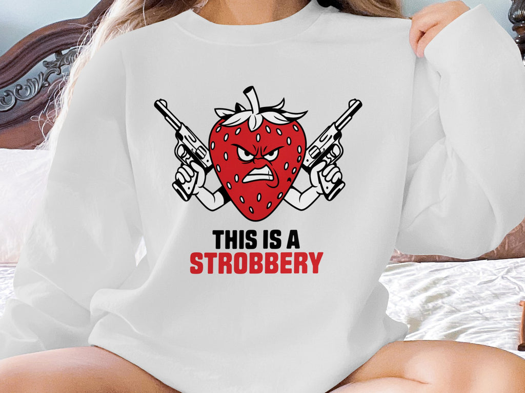 Red strawberry with guns, text "THIS IS A STROBERRY" on white sweatshirt.