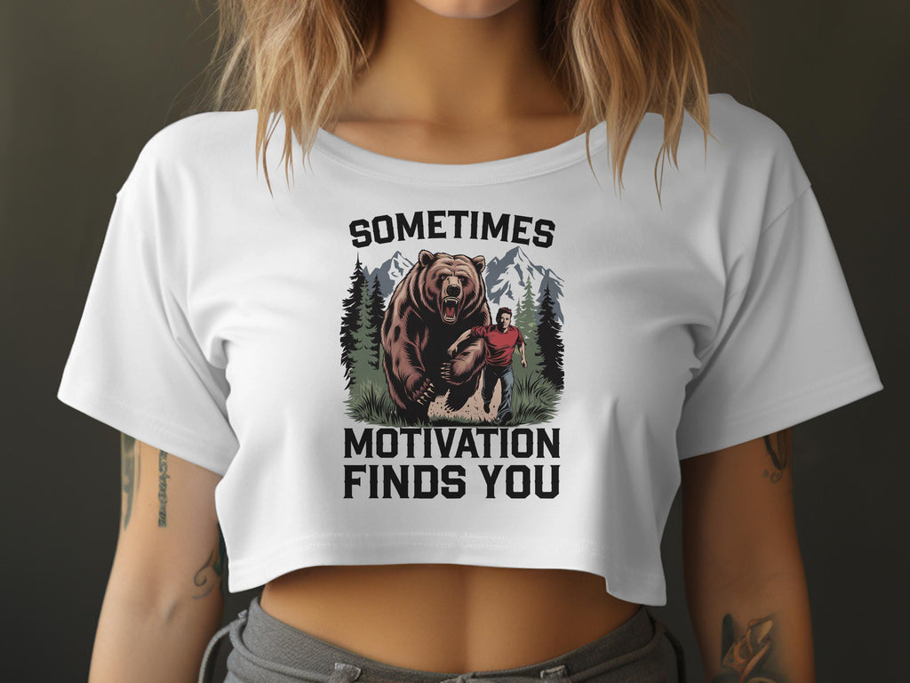 White cropped t-shirt with graphic art of a bear chasing a man in a forest.