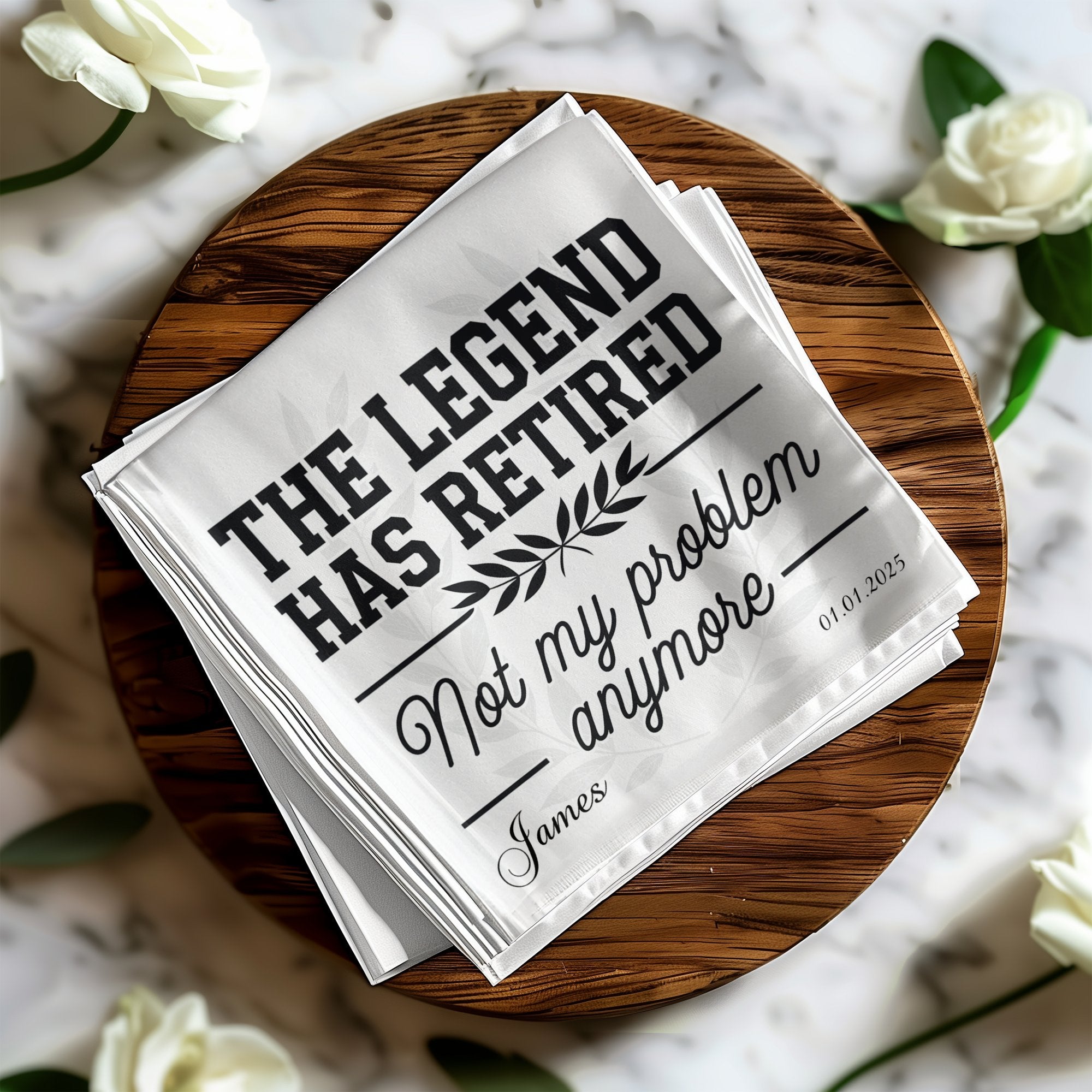 A folded white cloth with "THE LEGEND HAS RETIRED Not my problem James 01.01.2025" printed on it.