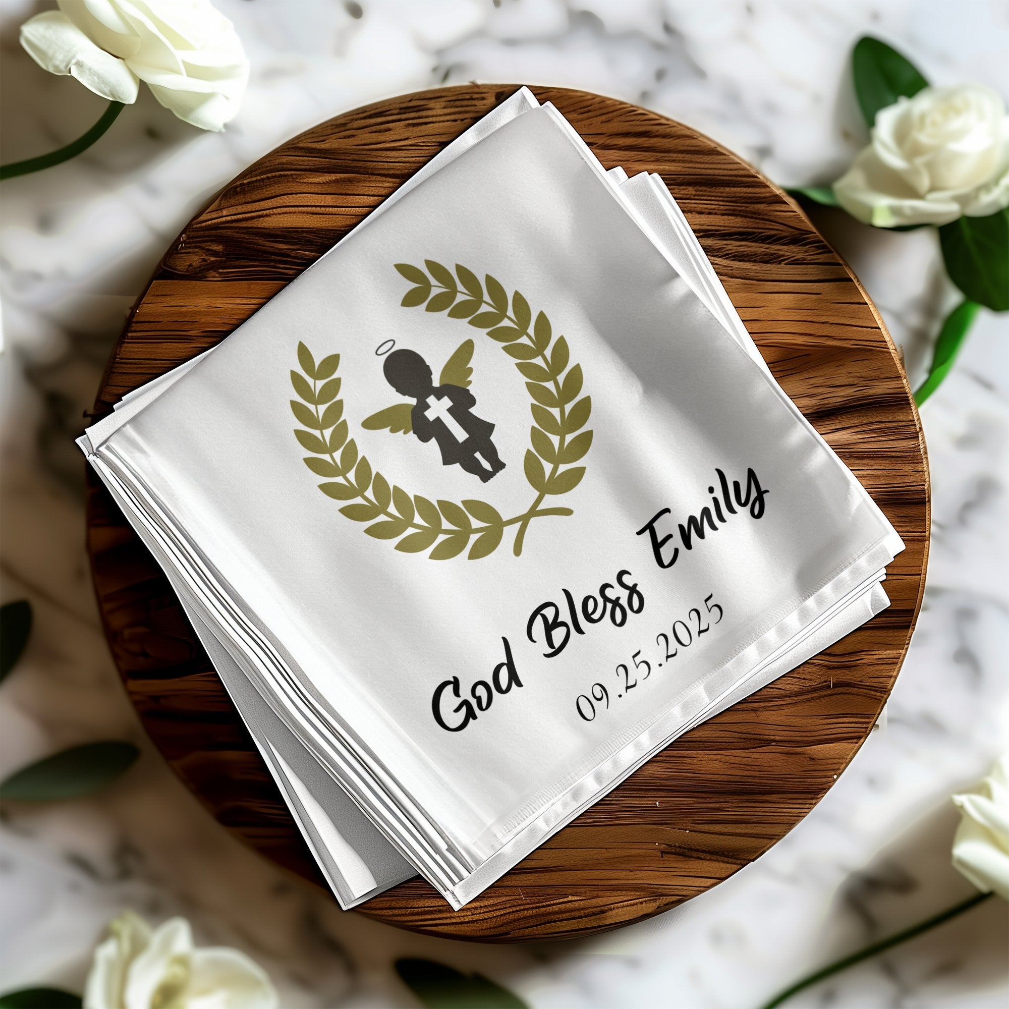 White fabric napkin with "God Bless Emily 09.25.2025" and angel.