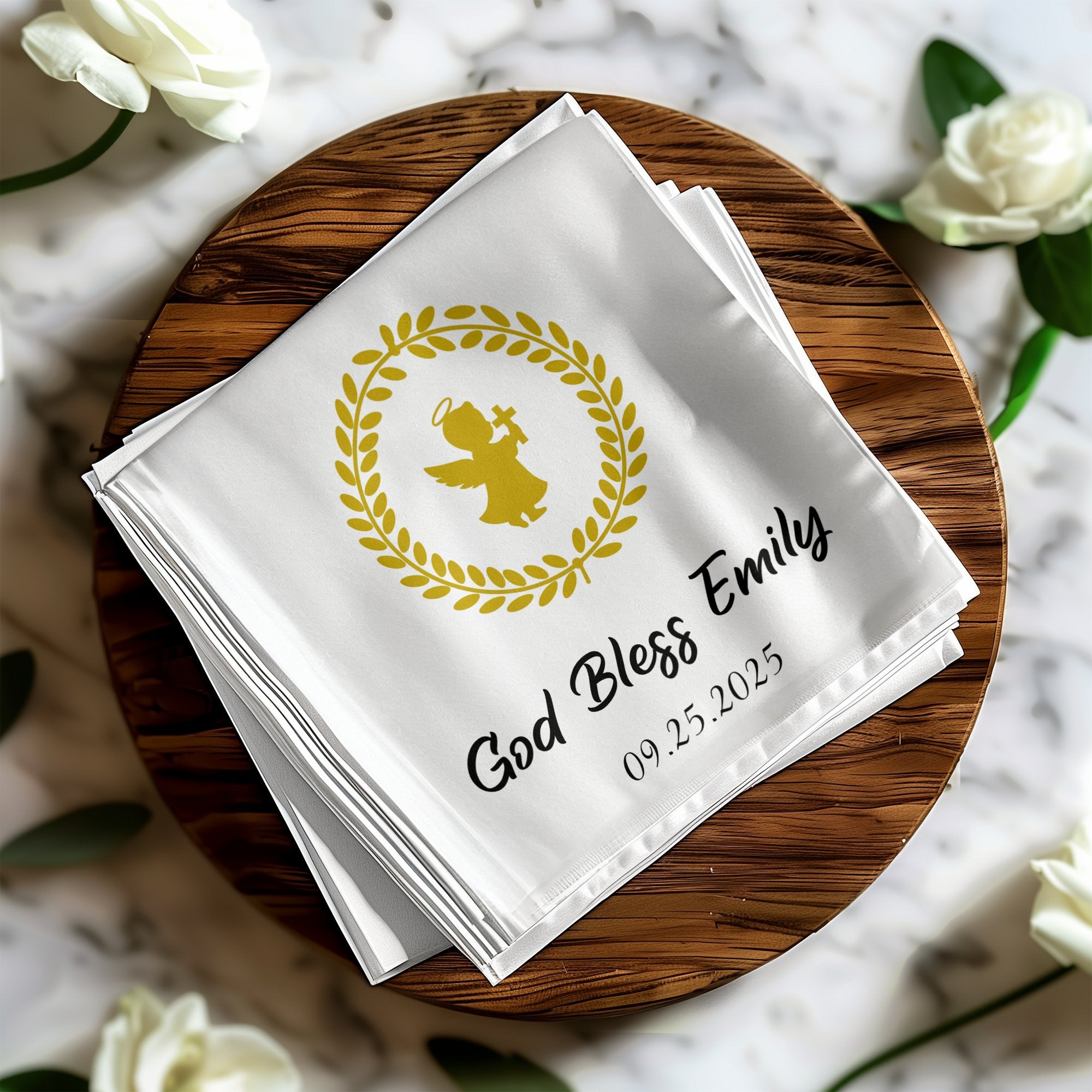 White cloth napkin with gold angel and "God Bless Emily 09.25.2025".