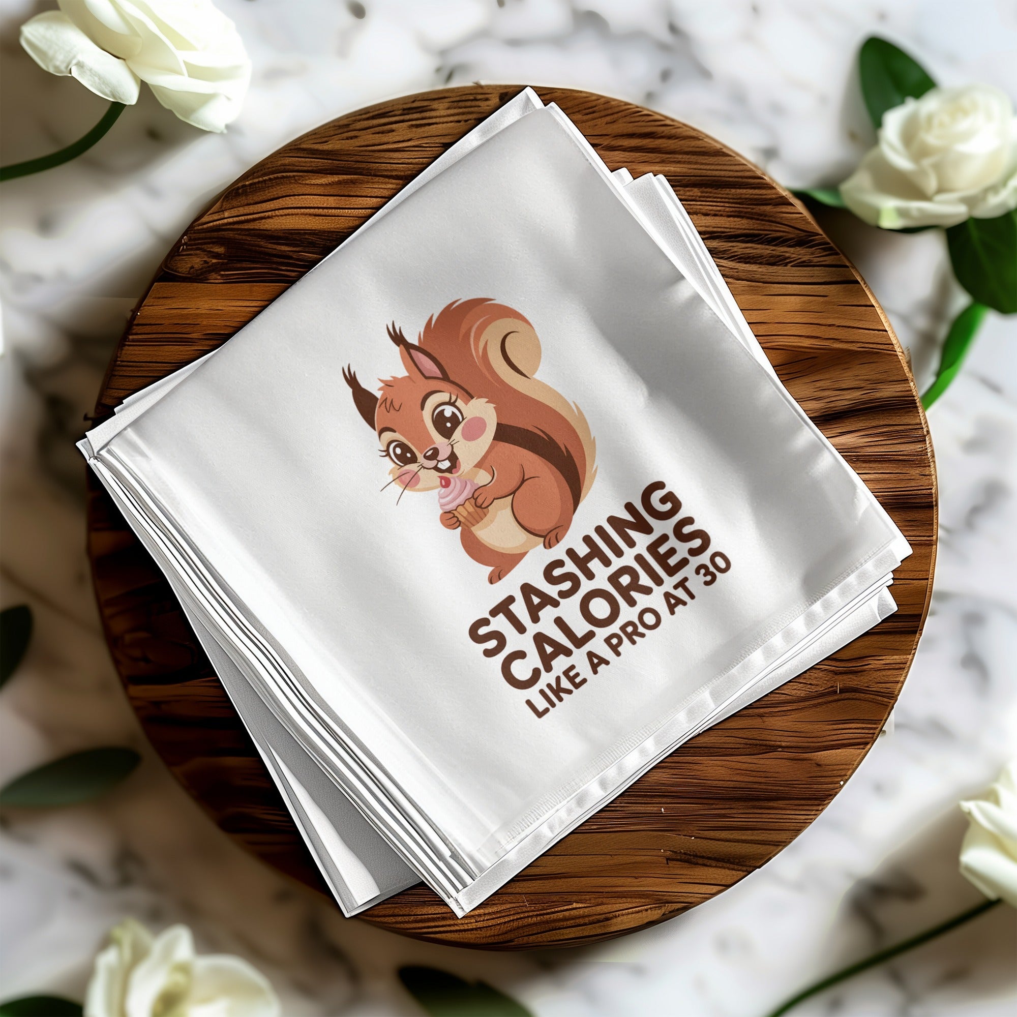 White napkin with a cartoon squirrel holding a cupcake and the text "Stashing calories like a pro at 30".