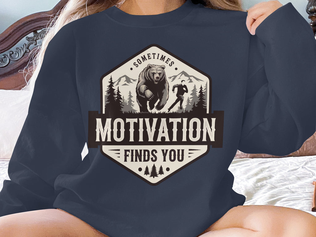 Navy sweatshirt with "Motivation Finds You" text and bear running graphic.