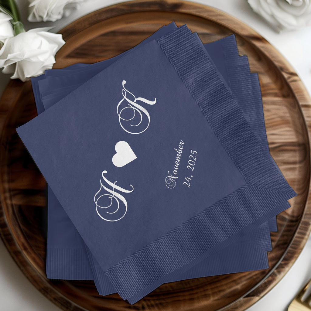 Navy cocktail napkins with white script initials "H & K" and "November 24, 2025".