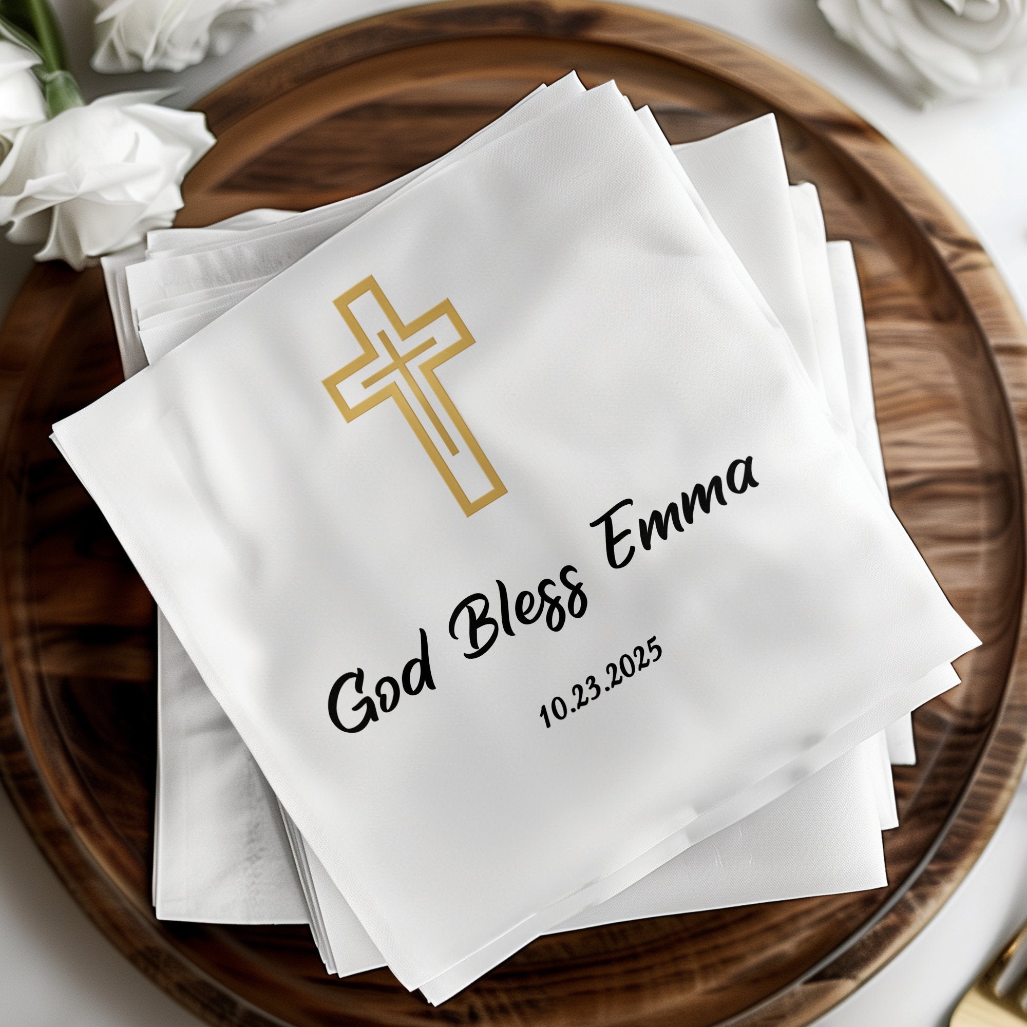 White napkins with gold cross, "God Bless Emma", and date 10.23.2025.