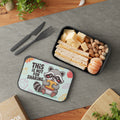 Lunchbox with raccoon graphic holding sandwich, containing sandwiches, cheese, and nuts.