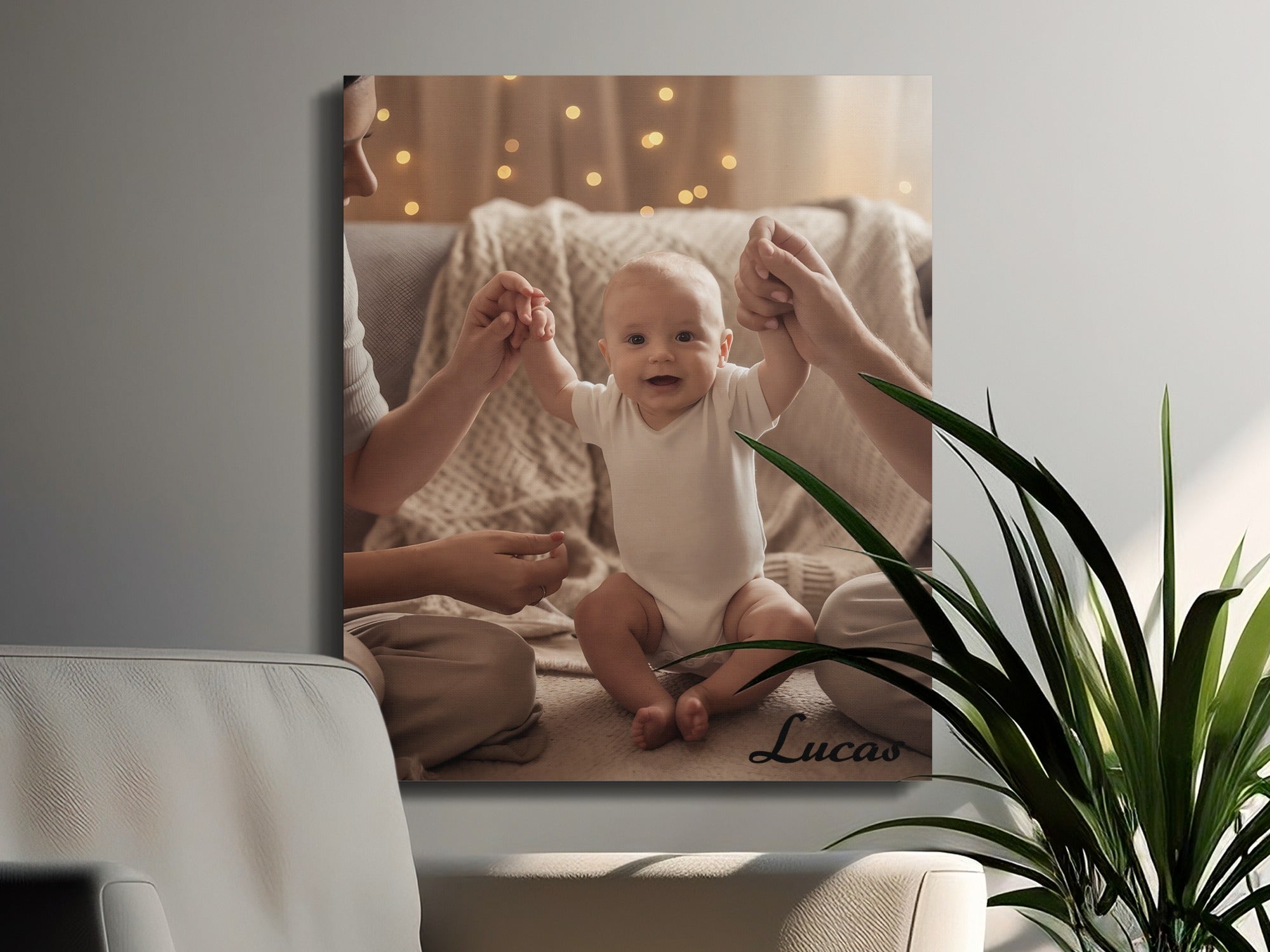 Canvas print of a baby being held up by adults' hands, with "Lucas" written on the canvas.