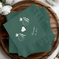 Green cocktail napkins with intertwined initials and a date.