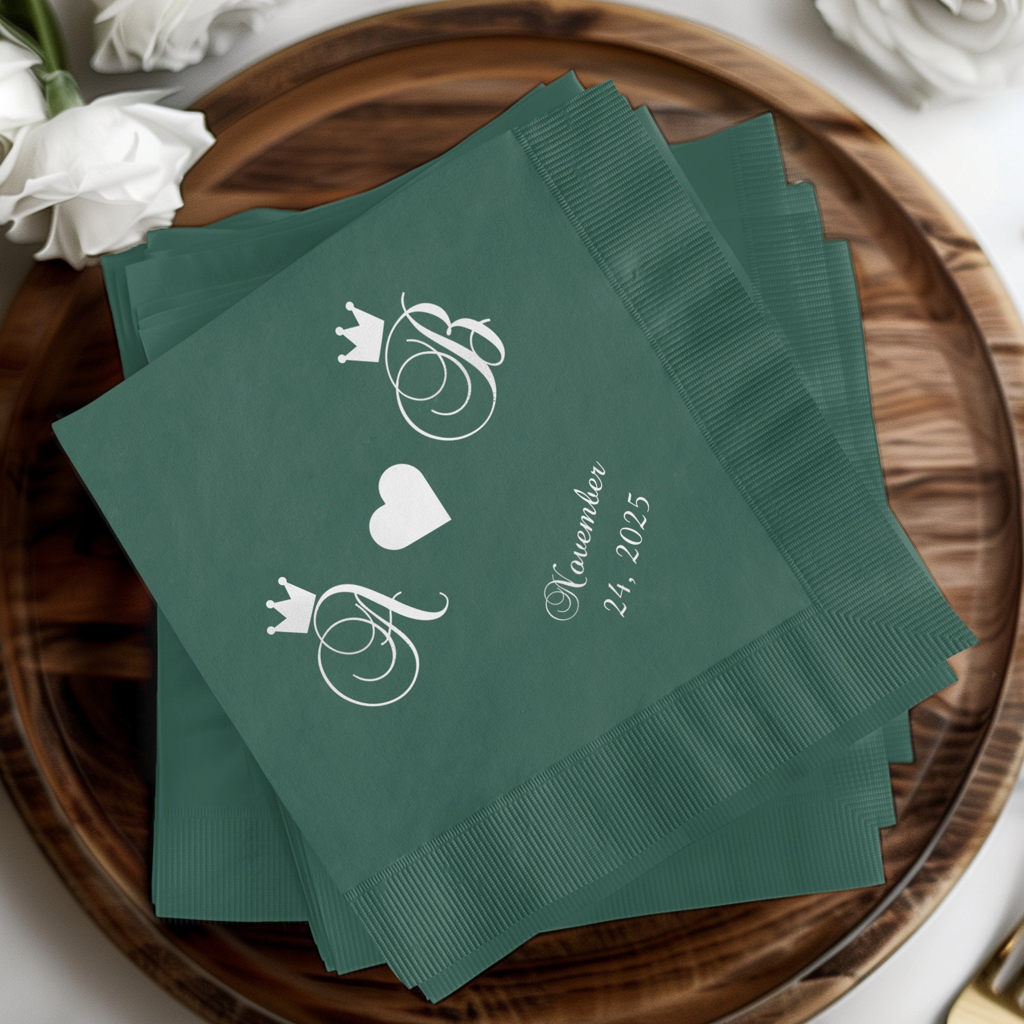 Green cocktail napkins with intertwined initials and a date.
