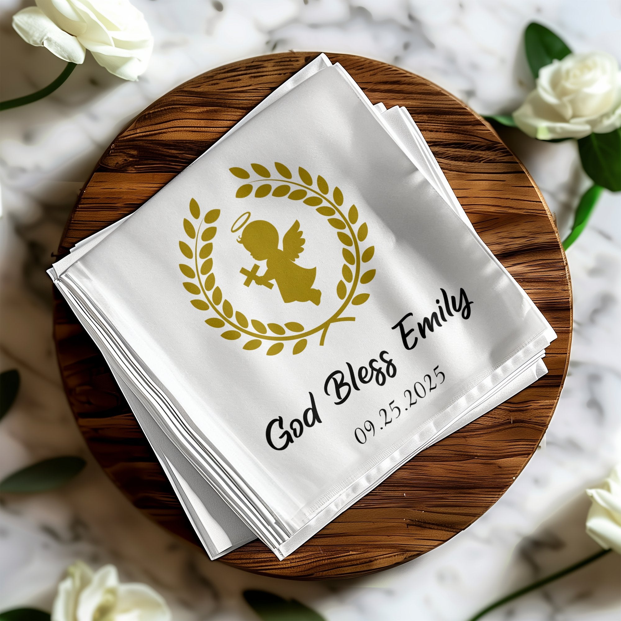 White folded napkins with gold angel, wreath, and "God Bless Emily 09.25.2025".
