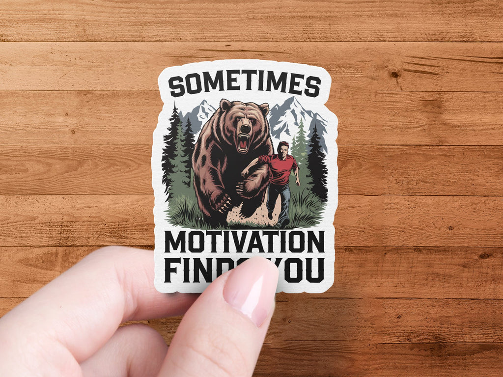 Sticker of a man running from a bear with text "SOMETIMES MOTIVATION FINDS YOU".