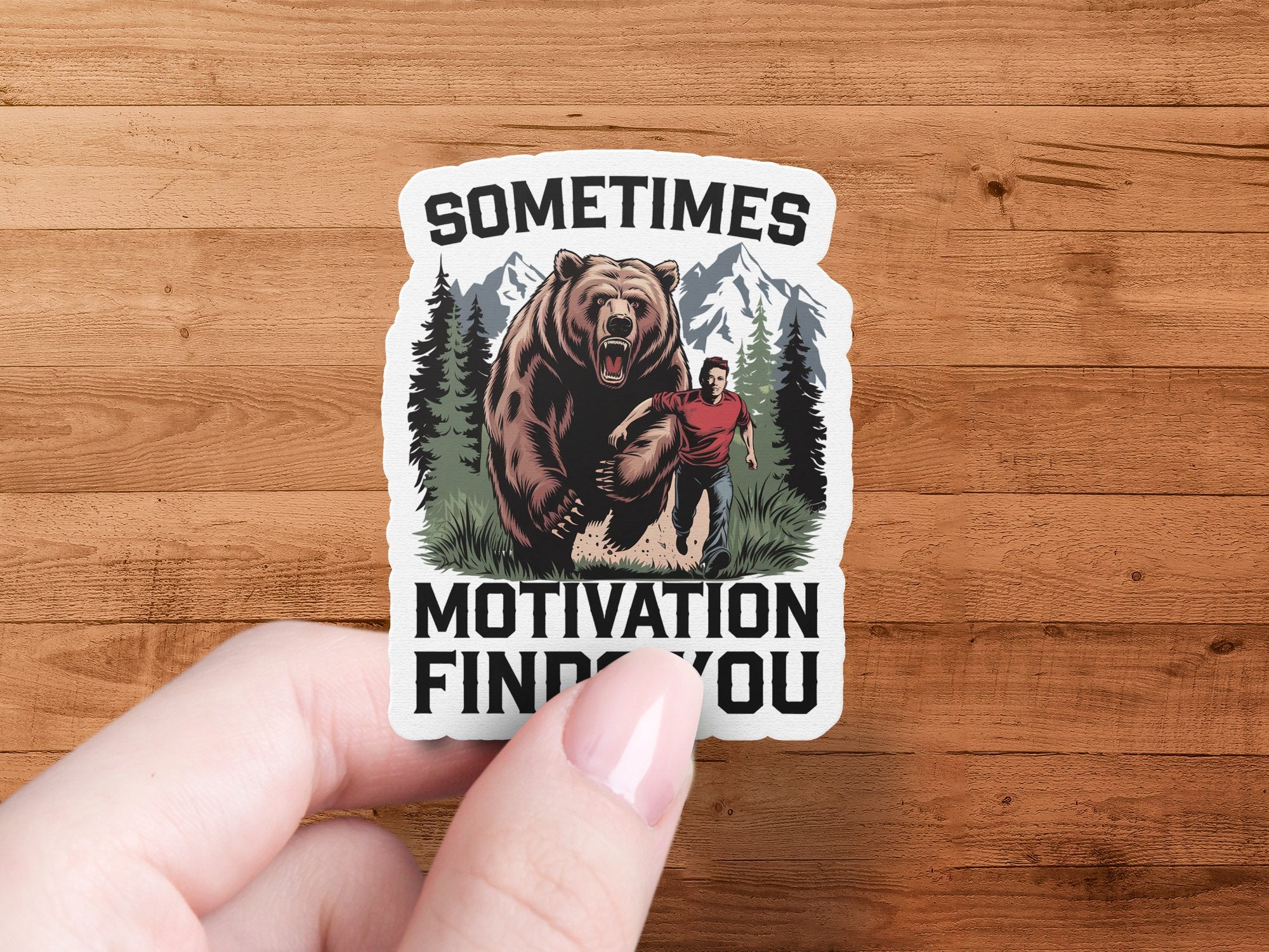 Sticker of a man running from a bear with text "SOMETIMES MOTIVATION FINDS YOU".