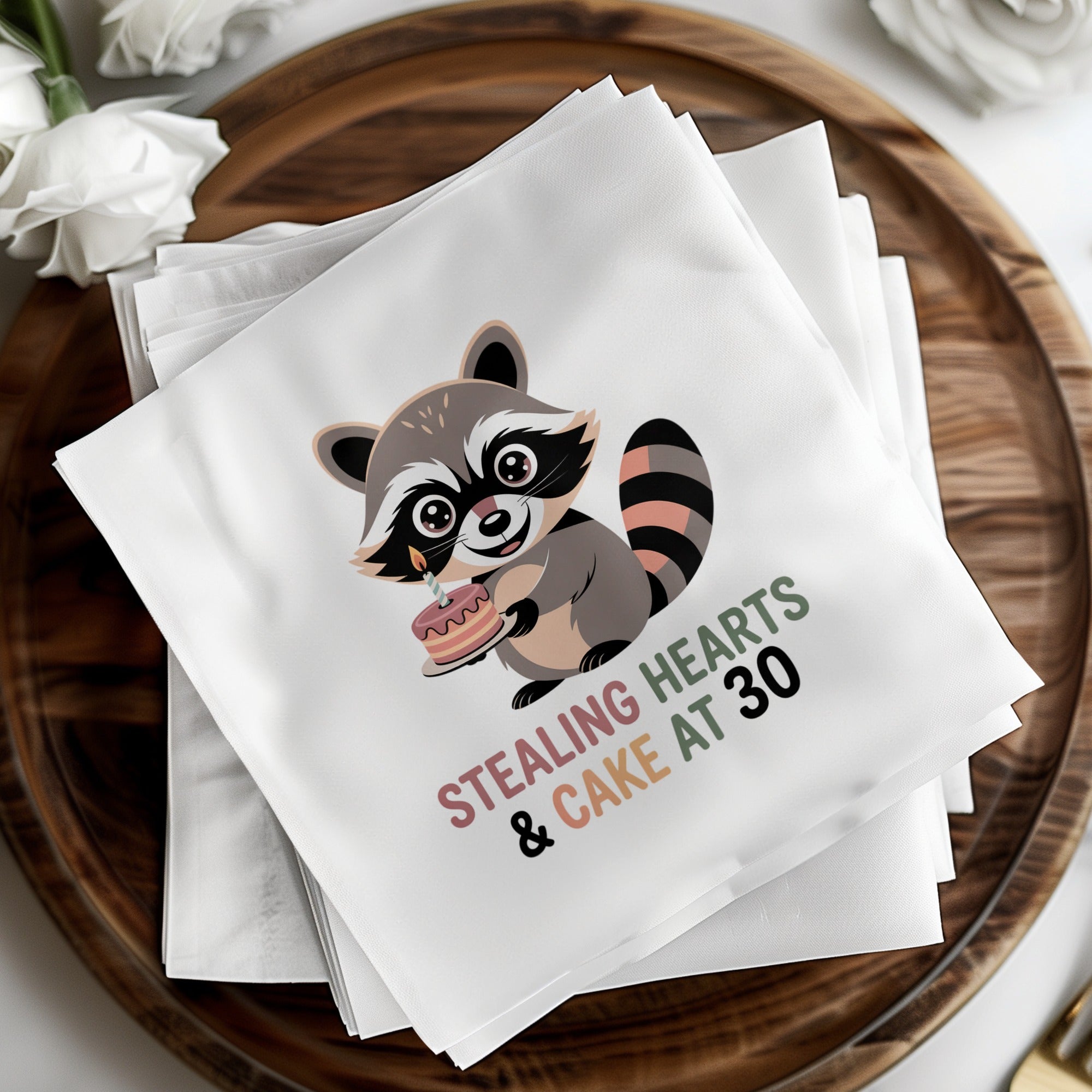 Napkins with a raccoon holding a birthday cake and text "Stealing Hearts & Cake at 30".