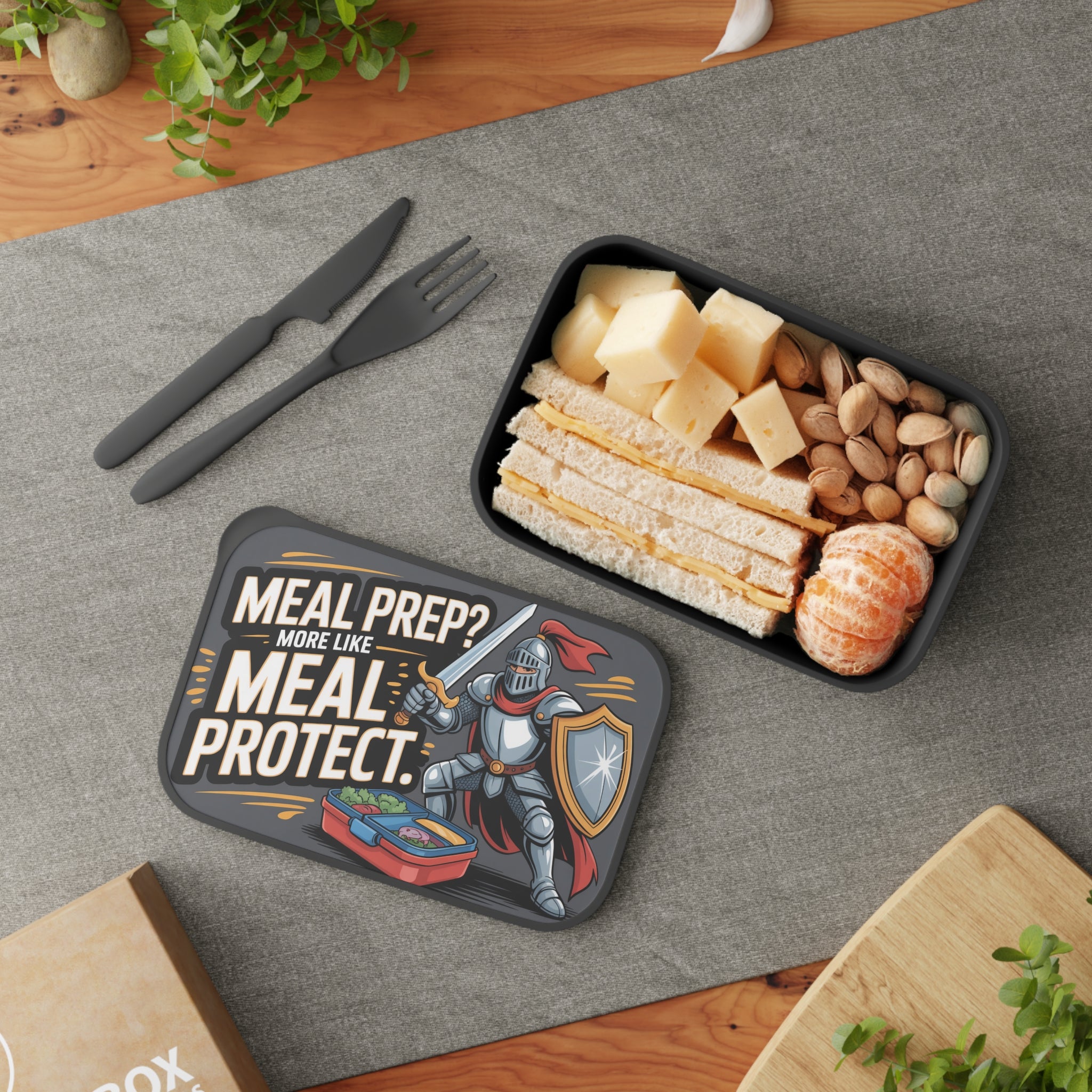 Lunchbox with sandwich, cheese, nuts, and oranges, featuring knight graphic.