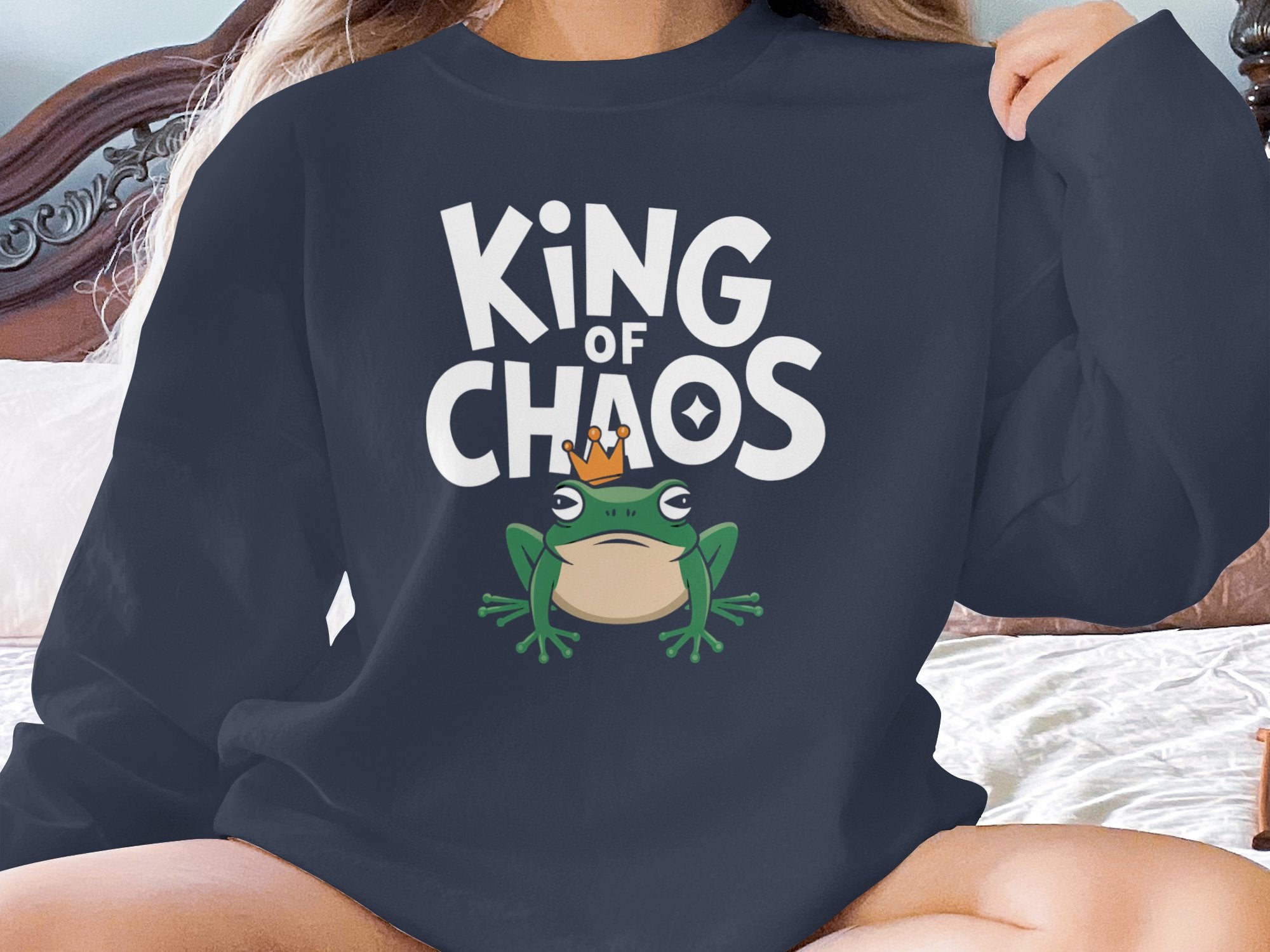 Dark sweatshirt with a frog wearing a crown and text "KING OF CHAOS".