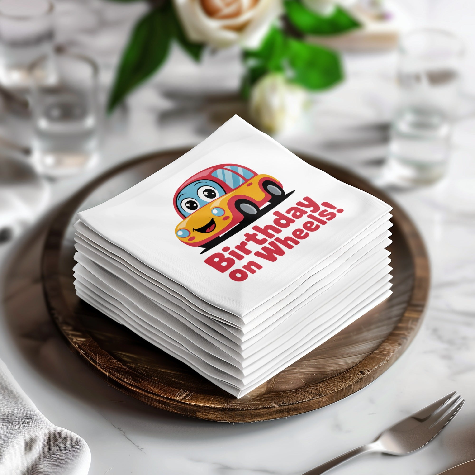 Stack of white napkins with cartoon car and "Birthday on Wheels!" text.