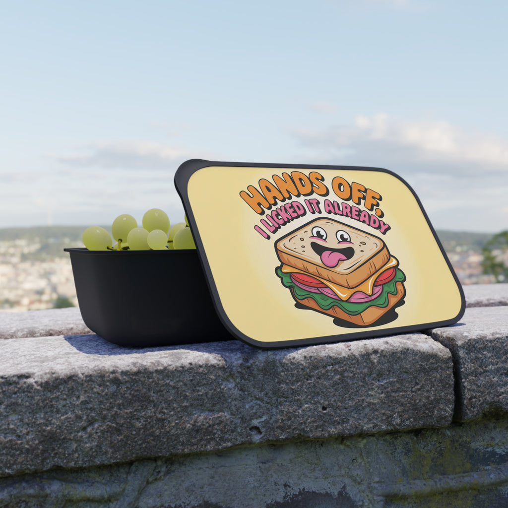 Lunchbox lid with sandwich graphic and text "Hands off I licked it already".