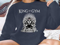 Gorilla on a throne of dumbbells with "KING OF GYM" text.