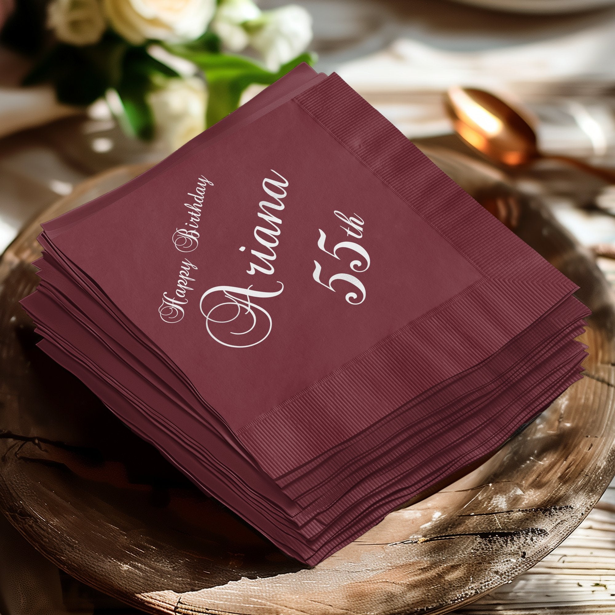 Burgundy napkins with "Ariana 55th Happy Birthday" in white script.
