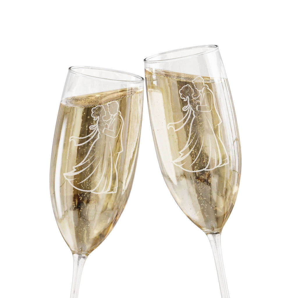 Two champagne flutes with etched bride and groom figures clinking.