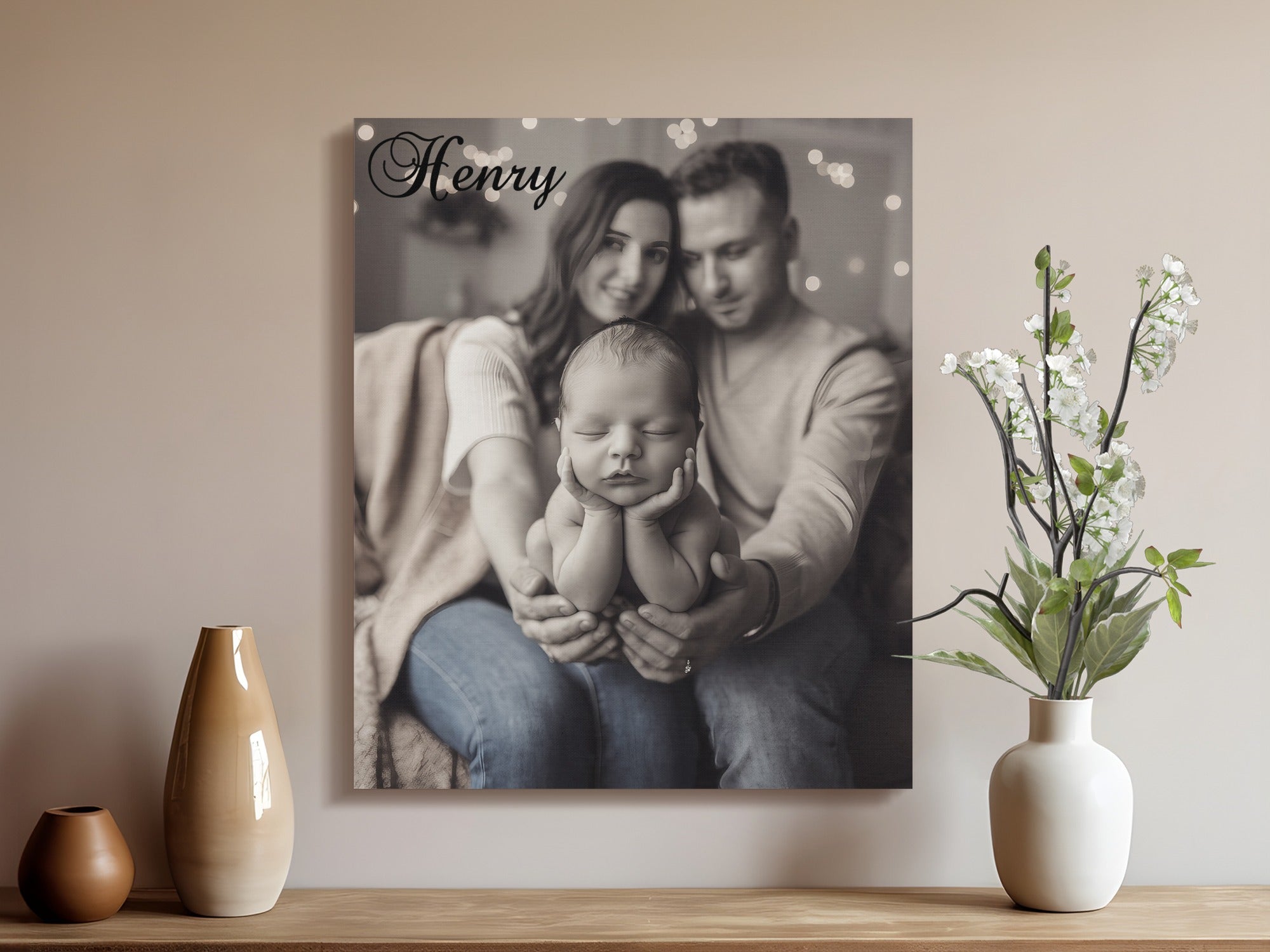 Newborn baby with parents on canvas print, text "Henry" above.