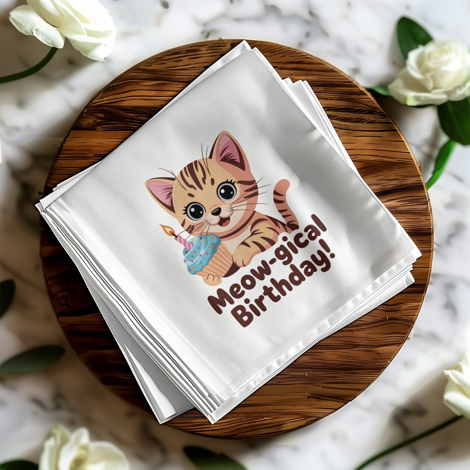 White napkin with cartoon cat and cupcake that reads "Meow-gical Birthday!".