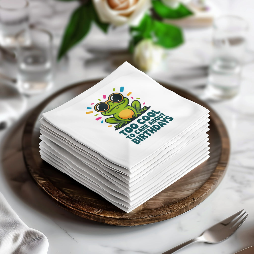 Stack of napkins with green frog wearing sunglasses and text "TOO COOL TO CARE ABOUT BIRTHDAYS".