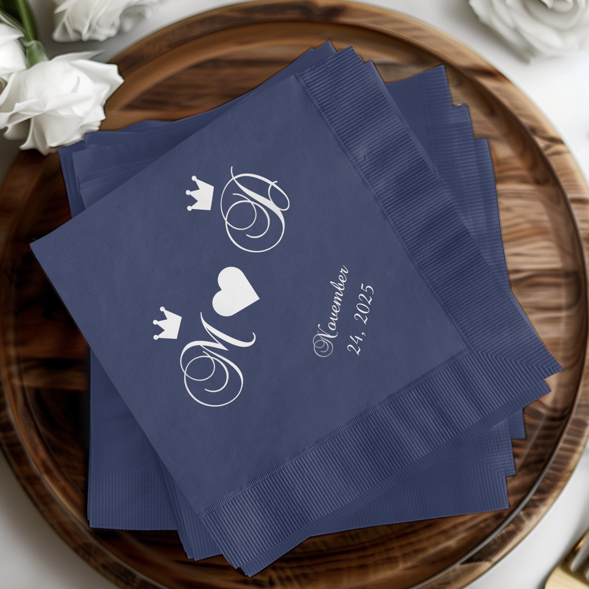 Navy blue napkins with crowned initials 'M' and 'J' and "November 24, 2025".