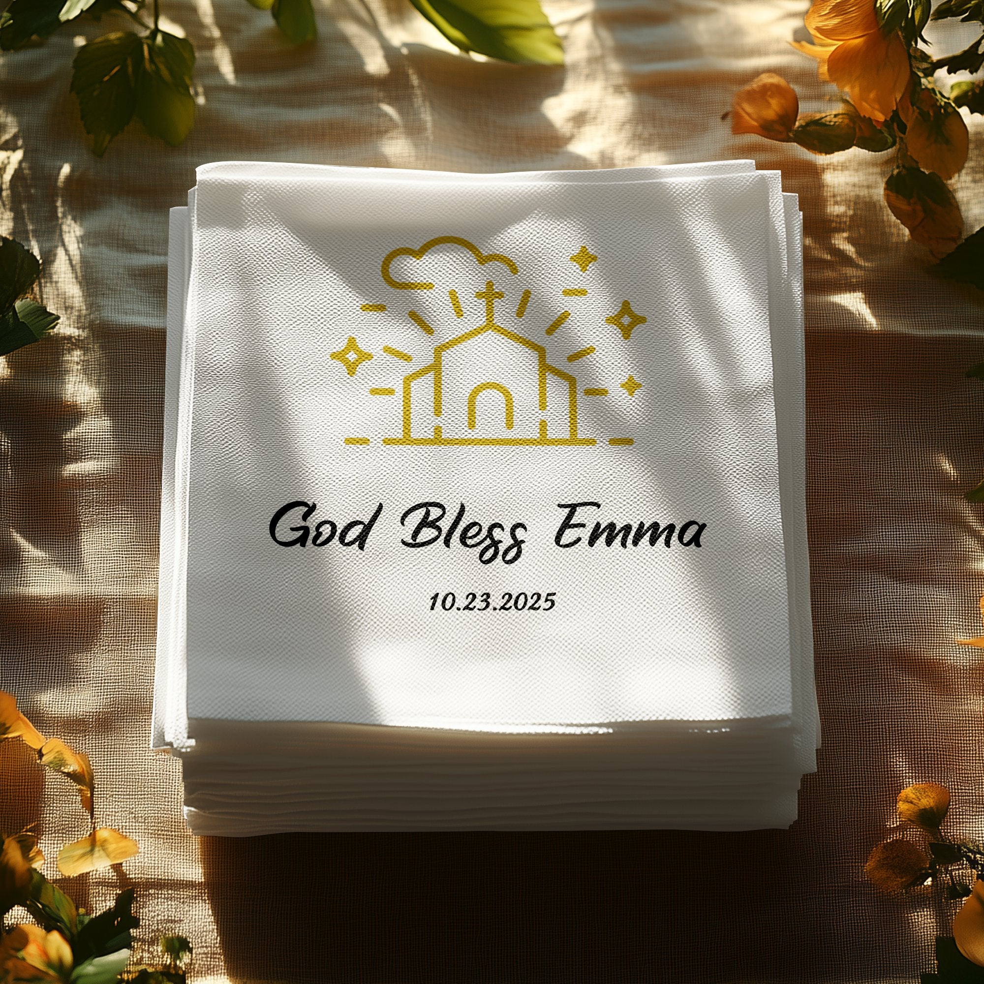 Stack of white napkins personalized with "God Bless Emma" and a date.