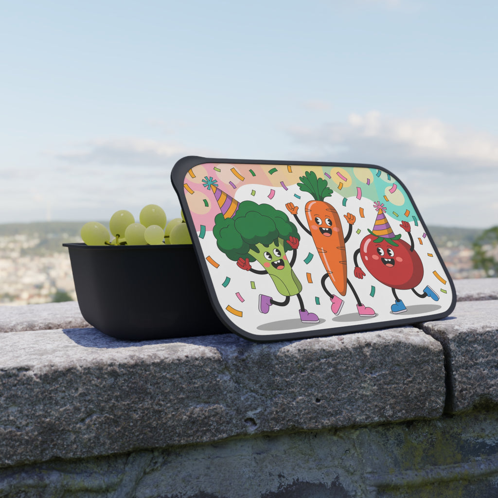 Cartoon broccoli, carrot, and tomato characters with party hats on a lunchbox lid.
