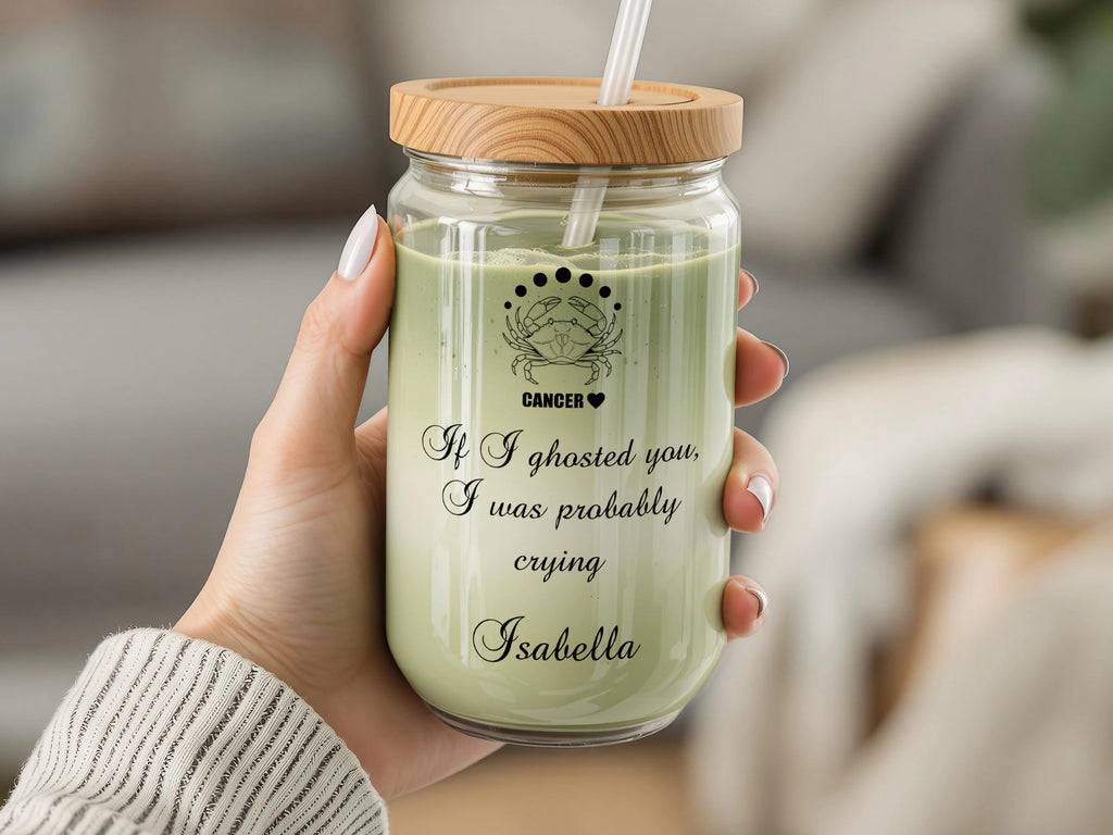 Cancer zodiac sign on glass cup with lid, straw, and text.