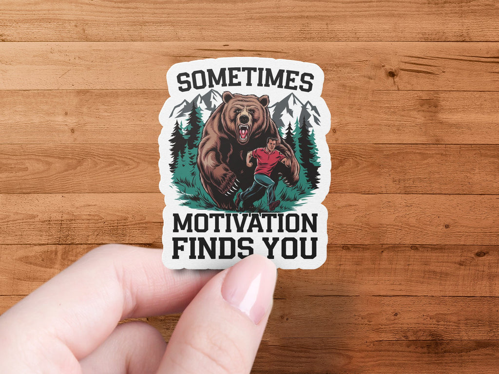 Sticker with bear chasing man and text "SOMETIMES MOTIVATION FINDS YOU".