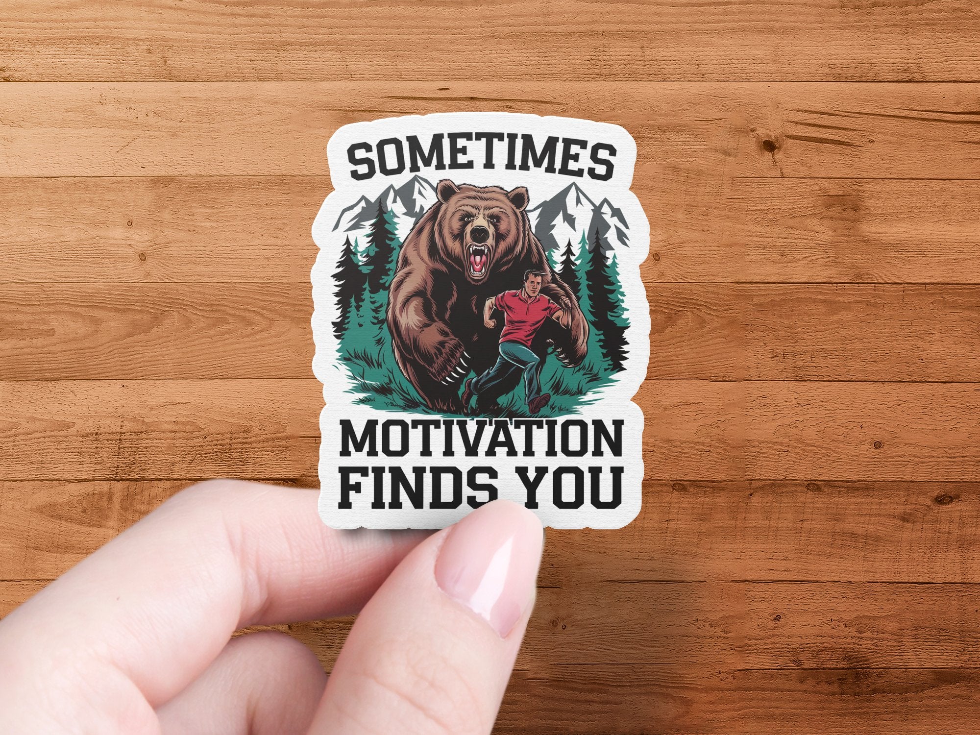 Sticker with bear chasing man and text "SOMETIMES MOTIVATION FINDS YOU".