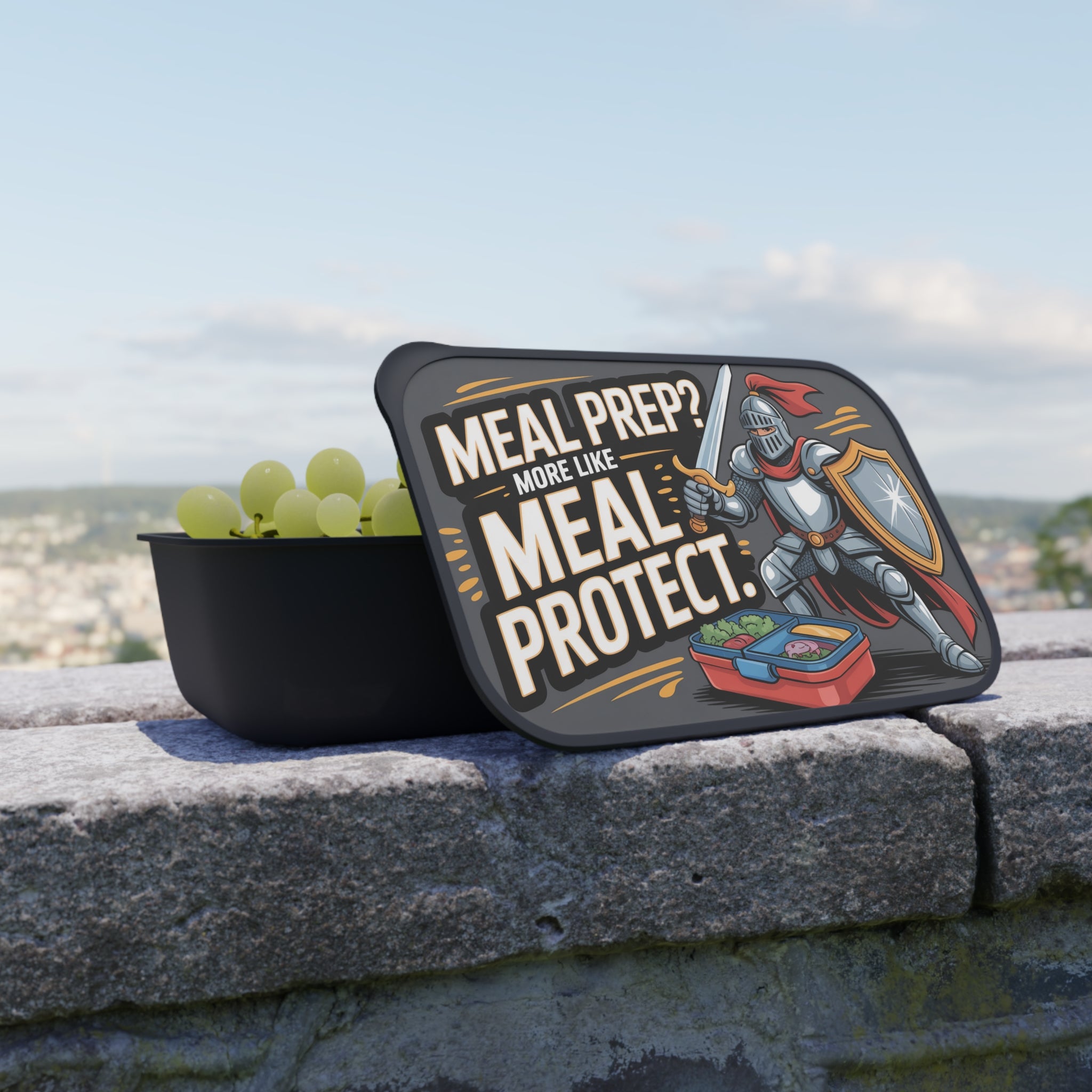 Black lunchbox with knight illustration and text "MEAL PREP? MORE LIKE MEAL PROTECT."