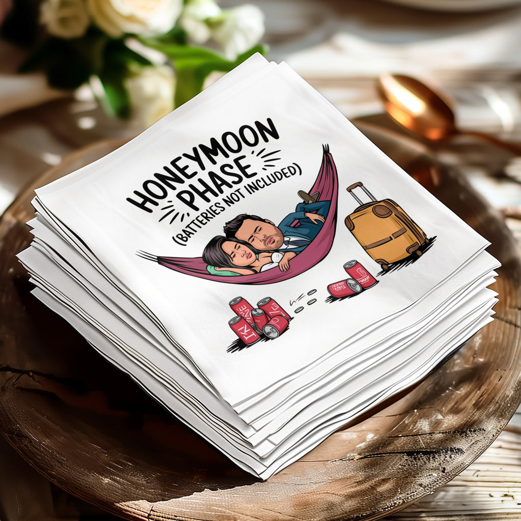 Napkins with cartoon couple in hammock, suitcase, and beer cans, reading "HONEYMOON PHASE".
