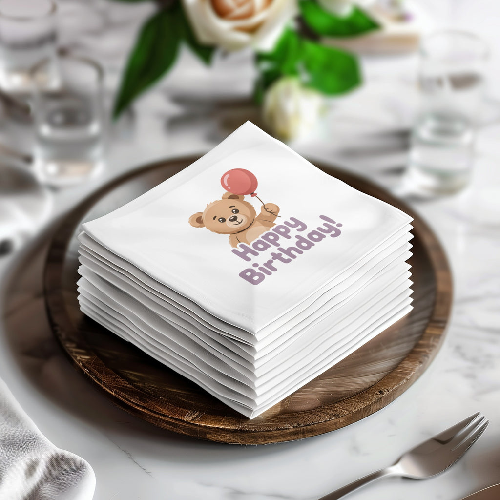Stack of white napkins with teddy bear and balloon saying "Happy Birthday!".