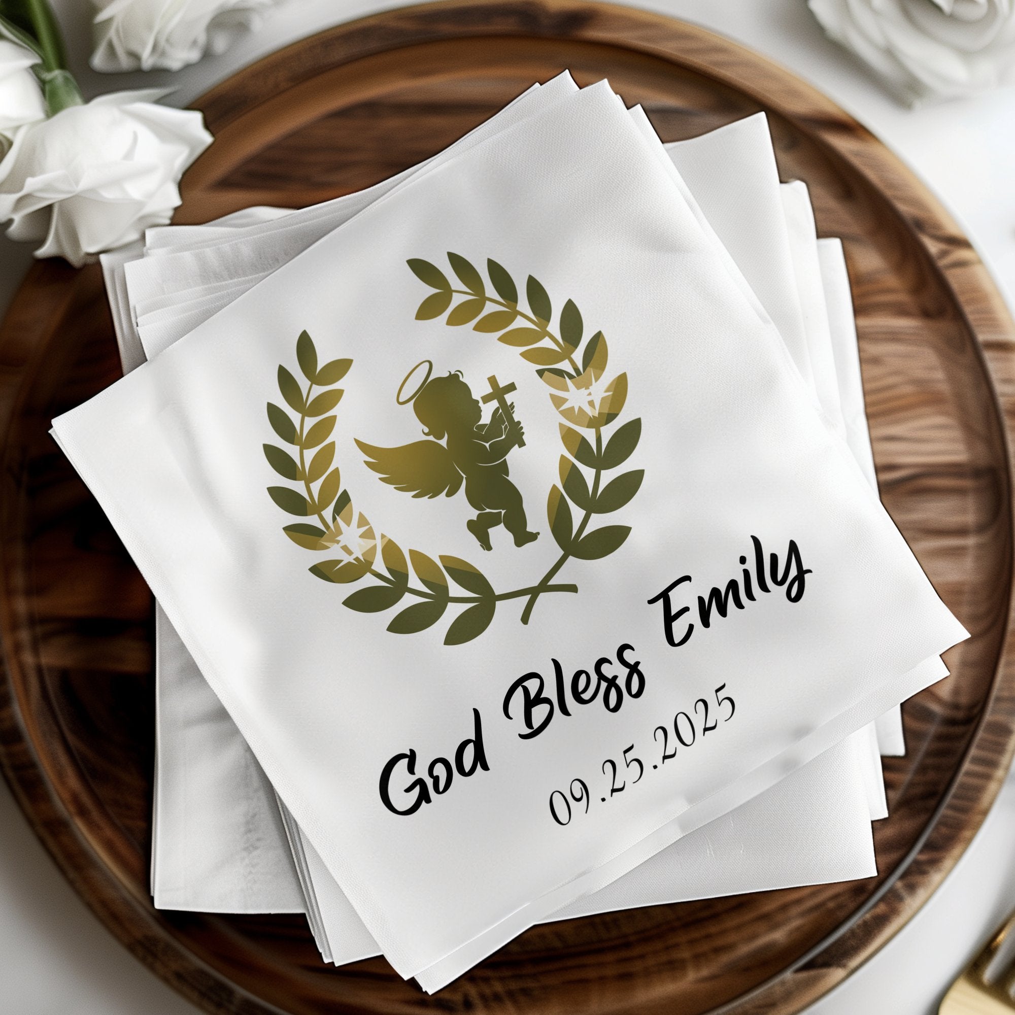 White napkin with golden angel, wreath, name, and date.