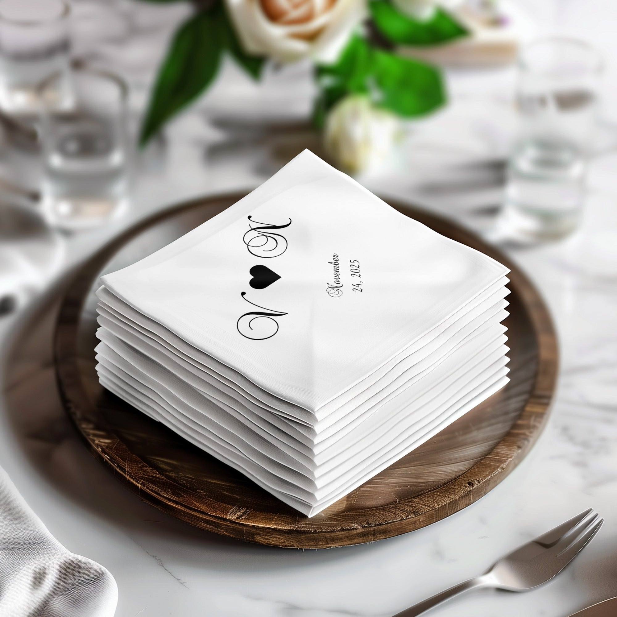 Stack of personalized wedding napkins with initials and date.