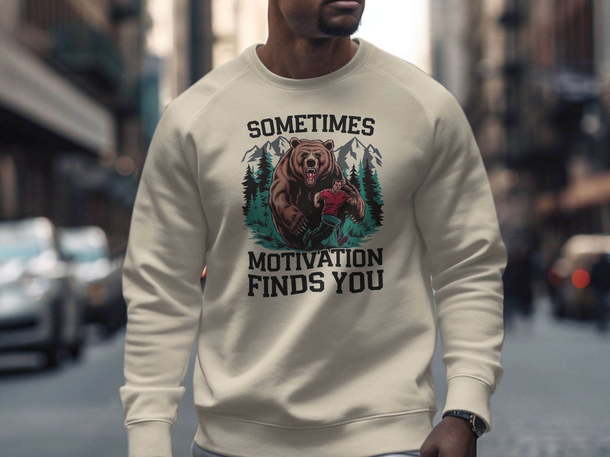 Cream sweatshirt with bear and hiker graphic and text: "Sometimes Motivation Finds You".