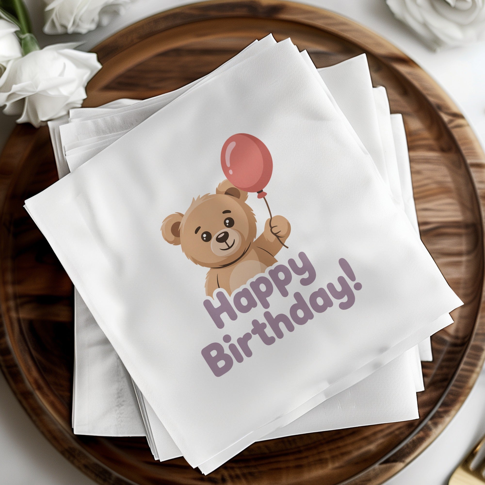 Teddy bear holding a balloon on a "Happy Birthday!" napkin.