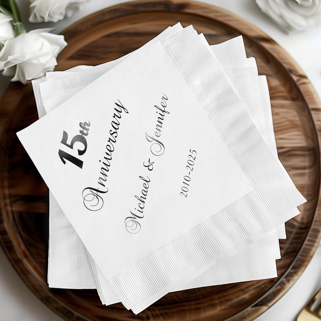 White paper napkins with "15th Anniversary Michael & Jennifer 2010-2025" printed in black.
