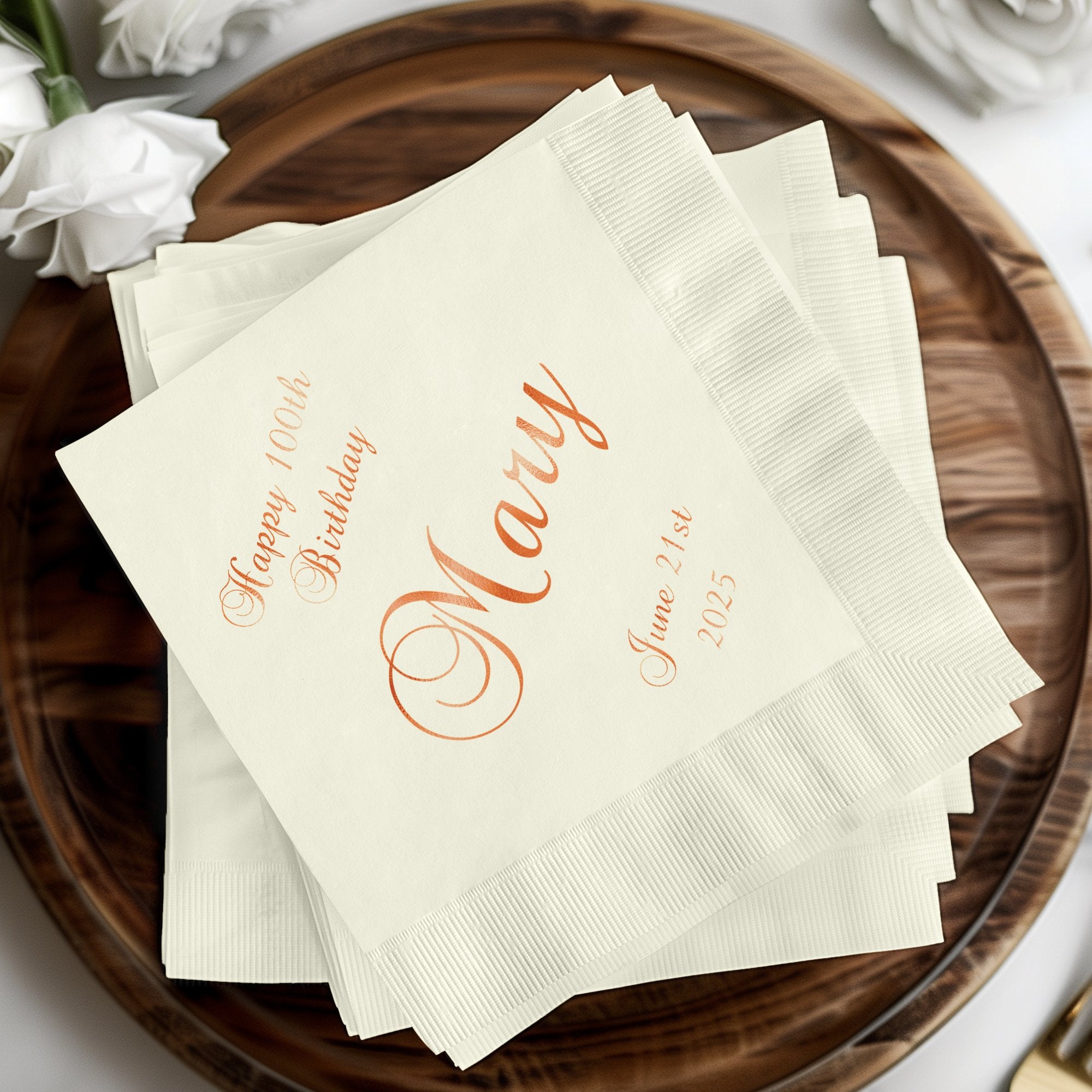 "Happy 100th Birthday Mary" in script on folded white napkins.