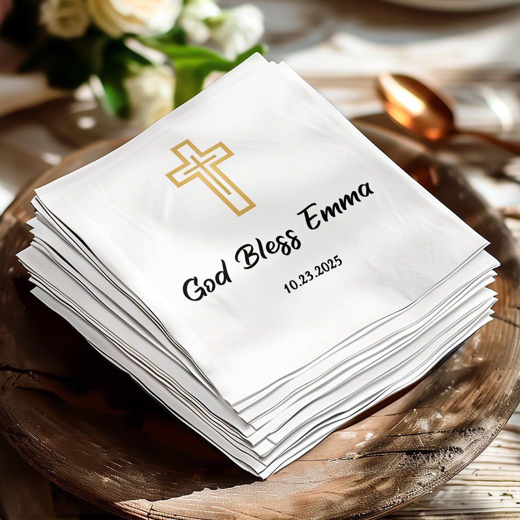 Stack of white napkins with gold cross and "God Bless Emma 10.23.2025".